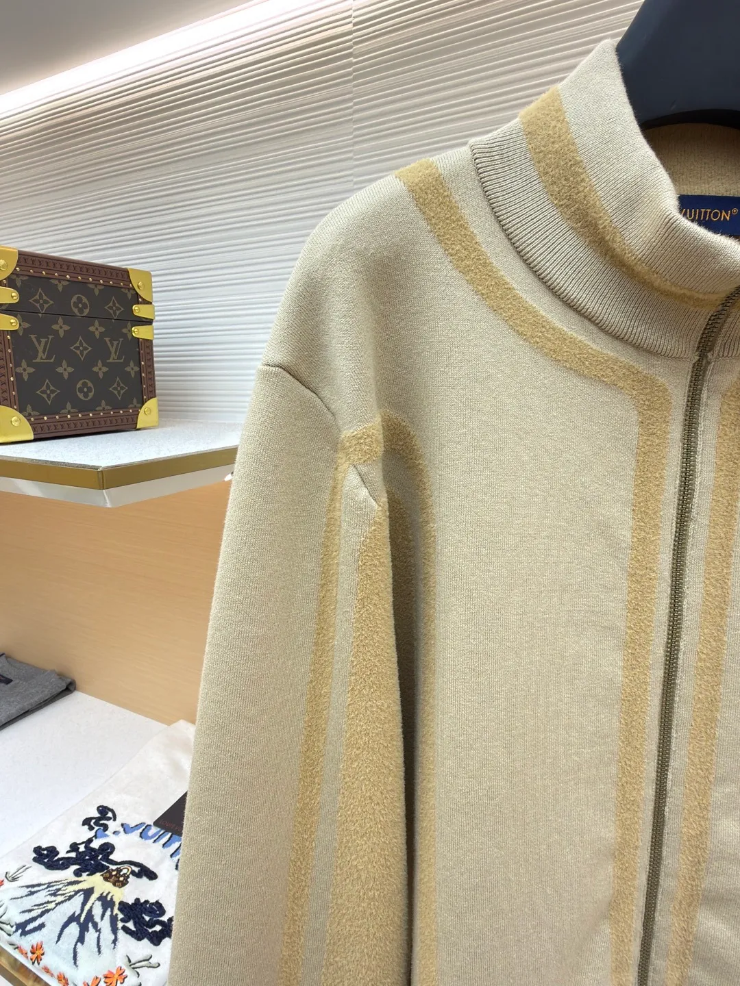 LOUIS VUITTON two-color splicing intarsia zipper jacket ●Original version: purchased and developed at 20700 ●Item number: 1681968-C15 ●Fabric: nylon fabric ●Technology: intarsia production ●Color: khaki ●Version: fitted version ●Weight: about 1020 grams ●Size: XS-S-M-L ●Description: Made of 43% nylon, 32% cotton and 25% viscose blended fabric, which has both comfort and stiffness. The designer used two-tone intarsia technology to allow contrasting color strips to run through the sleeves and body, forming a smooth visual extension. Different areas create subtle three-dimensional texture effects by changing knitting density and stitching methods. The chest is decorated with a delicate intarsia LV logo, and the Vuitton word is presented in elegant font on the back, showing brand recognition in every detail. The collar, cuffs and hem made of rib knitting technology not only enhance the stability of the silhouette, but also echo the overall design language. The front placket features a smooth zipper closure and practical slip pockets on both sides for added functionality. The entire piece perfectly interprets the exquisite aesthetics of sports and leisure style through the ingenious combination of fabric texture and craftsmanship details. The overall wiring is straight and delicate, the fabric is comfortable and soft, and the color is consistent without color difference. It can be matched with the same style to create a fashionable look and control various occasions. Customized accessories, complete with three standards, same style for men and women!